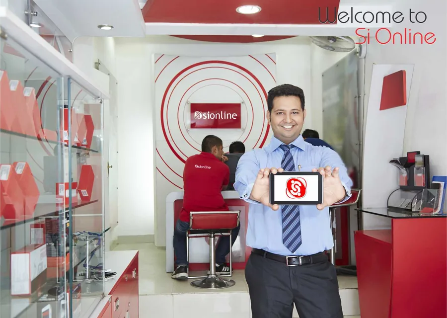 A SiOnline branded service counter with a staff member holding a tablet